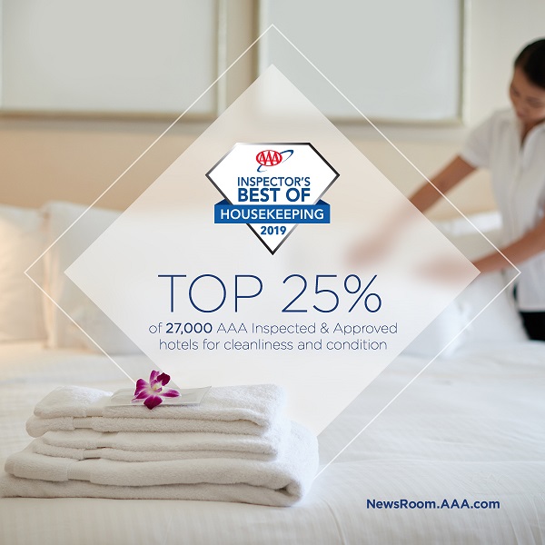 Best of Housekeeping award with maid folding towels in the background 