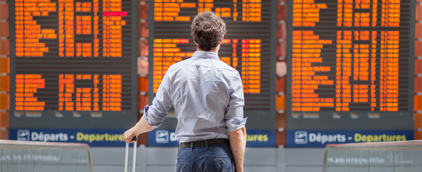 man standing in front of listing of flights