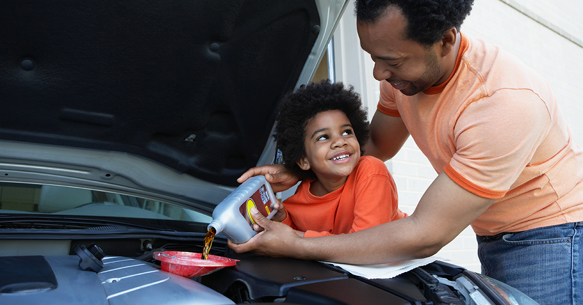father and son changing oil