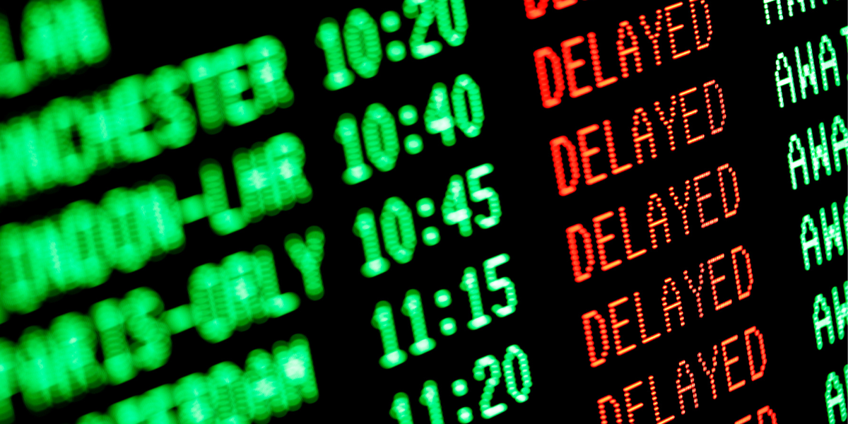 Close up of a flight board at an airport showing delayed flights