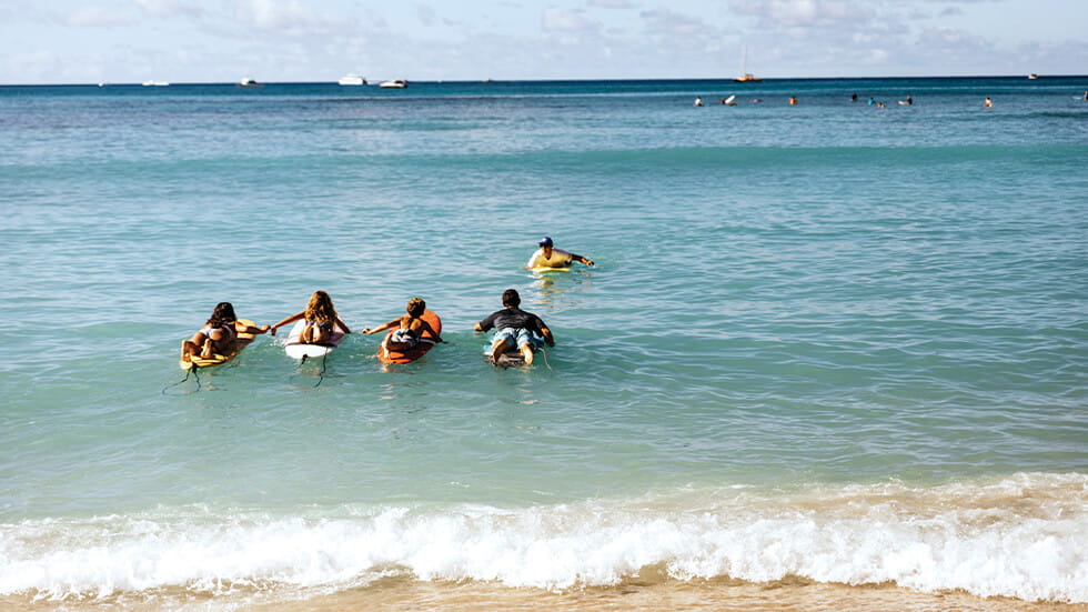 Family attending surf lessons in Hawaii Photo courtesy of Hawaii Tourism