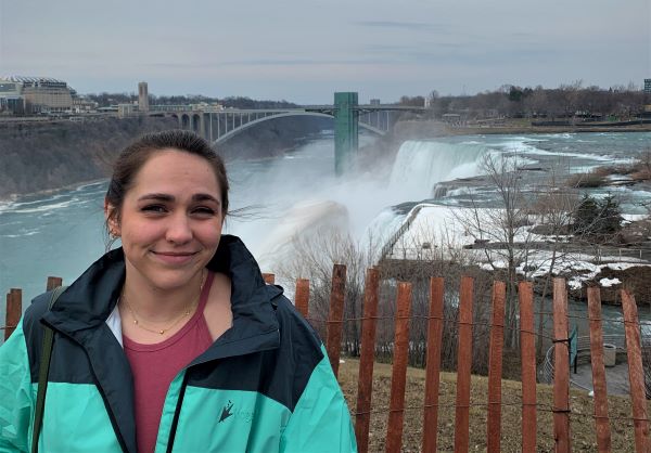 Valerie poses for the camera, with the rushing water of Niagara Falls' rapids in the background.
