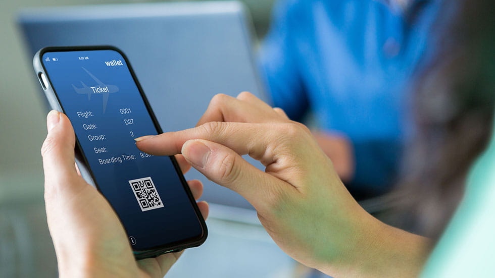person holding phone looking at digital airline ticket